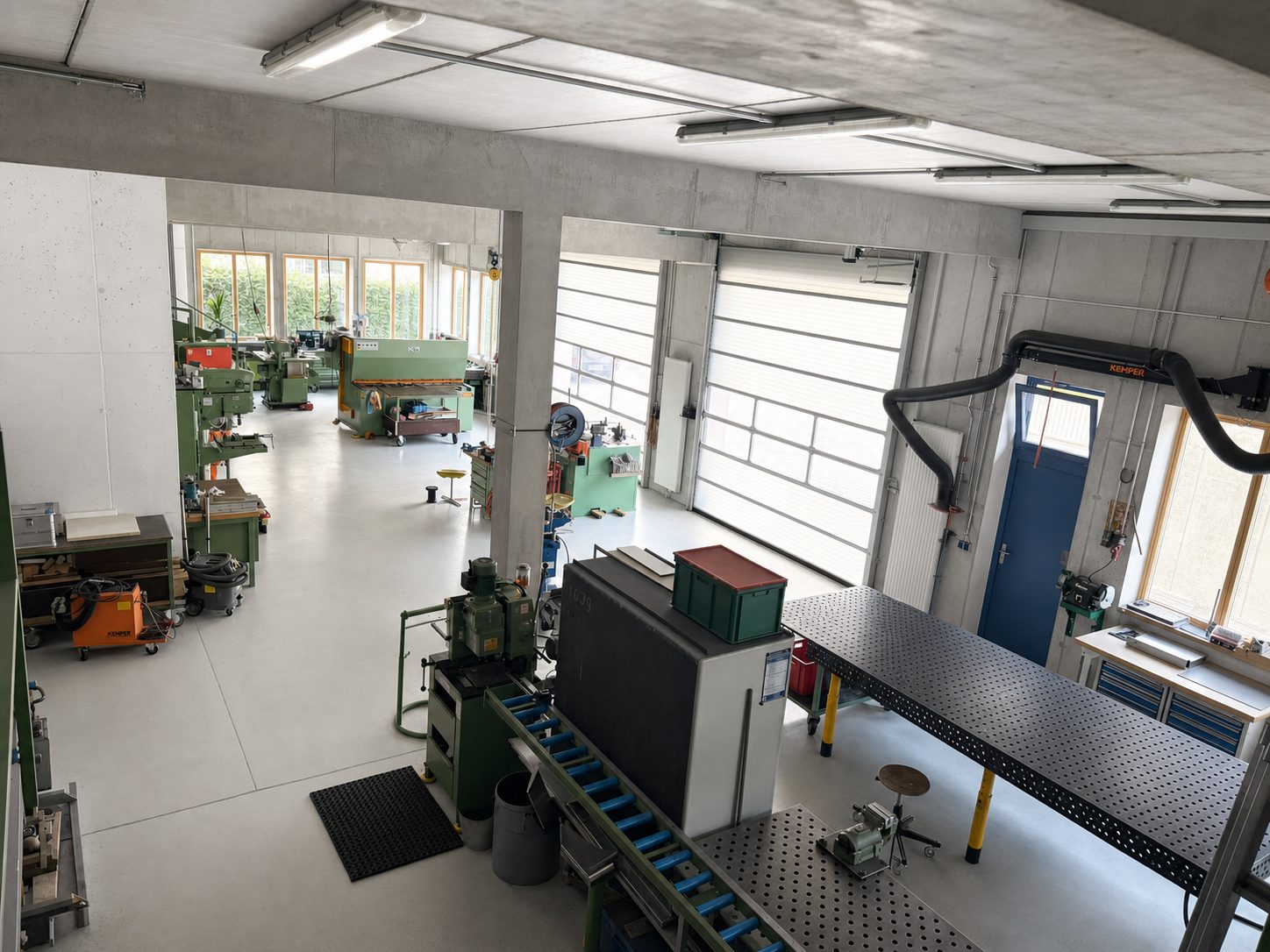 Blick in die Werkstatt mit Schweißtisch, Absaugung und Maschinen